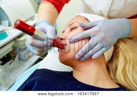 Young woman with good skin having Dermabrasion Cosmetic Treatment with mechanical instrument at SPA Salon