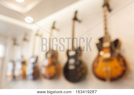 Blur abstract background with guitars hanging on white wall, stock photo