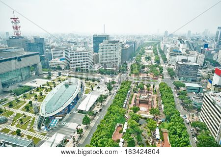 Travel concept - Panoramic modern city bird eye view on Nagoya TV Tower landmark of Nagoya. Oasis21 Aichi art center and holly tree plaza under modern city with blue and sunny morning sky in Japan