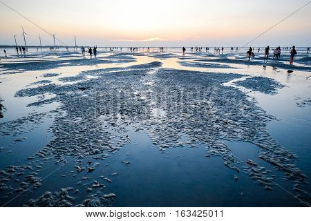 Asia culture - Beautiful landscape of sea level reflect fantasy dramatic sunset sky and people's silhouette in Gaomei wetlands the famous travel attractions in Taichung Taiwan.