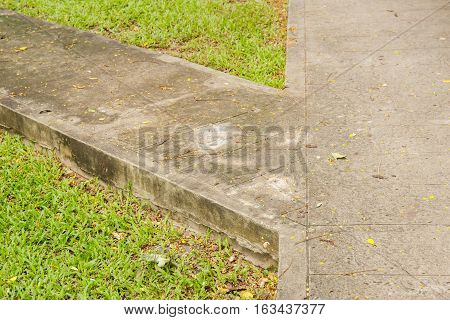 Junction of walking path or walkway or walkpath in garden with green grass.