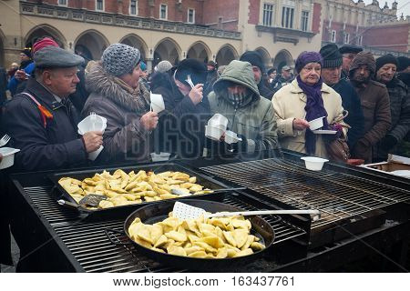 CRACOW POLAND - DECEMBER 18 2016: Christmas Eve for poor and homeless on the Central Market in Cracow. Every year the group Kosciuszko prepares the greatest eve in the open air in Poland