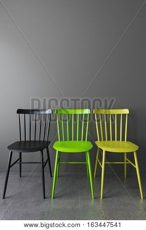Three simple chair in empty room with gray walls and a concrete floor. Interior illustration 3d render.