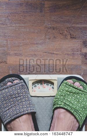 close up image of Man standing on weight scale