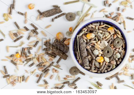 dry food for rodents in bowl on white background top view.