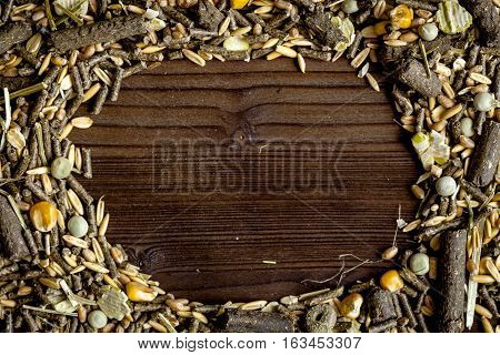 dry food for rodents on dark wooden background top view.