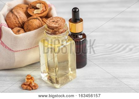 cosmetic and therapeutic walnut oil on wooden background.