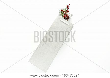 Champagne bottle in silver glitter gift bag with decoration on white background with copy space.