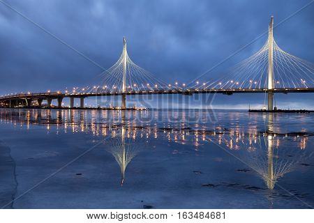 Western high-speed diameter in Saint-Petersburg. The new cable-stayed bridge across the Neva river is reflected in the ice.