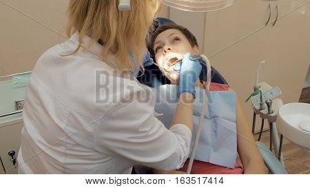 Woman at the dentist clinic office gets dental medical examination and treatment. Odontic and mouth health is important part of modern human life that dentistry help with.