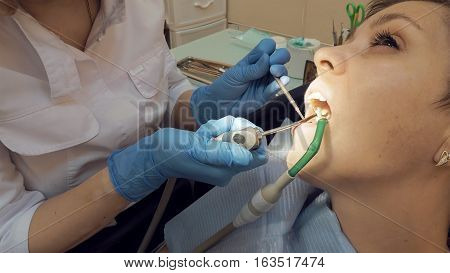 Woman at the dentist clinic office gets dental medical examination and treatment. Odontic and mouth health is important part of modern human life that dentistry help with.