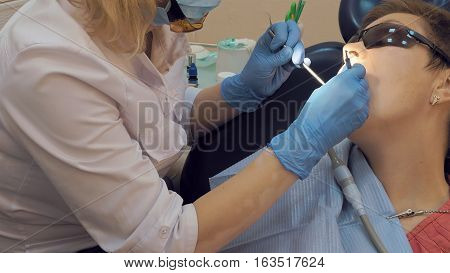 Woman at the dentist clinic office gets dental medical examination and treatment. Close up shot. Odontic and mouth health is important part of modern human life that dentistry help with.