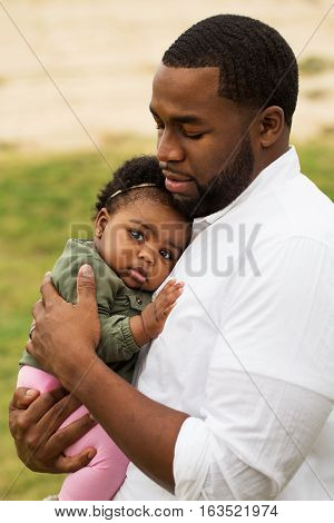 African American loving father holding his daughter.