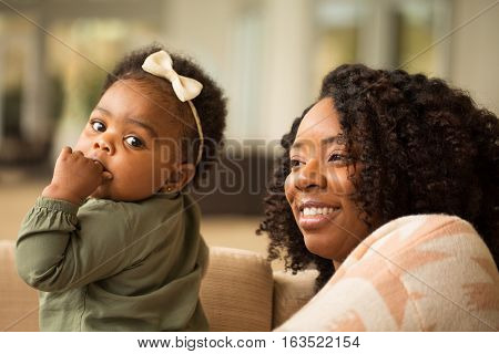 Happy African American mother and daughter playing.