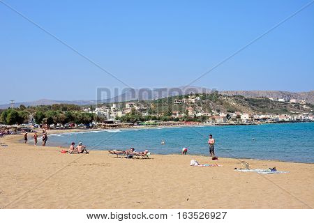 KALYVES, CRETE - SEPTEMBER 16, 2016 - Tourists relaxing on the beach with views towards the mountains Kalyves Crete Greece Europe, September 16, 2016.