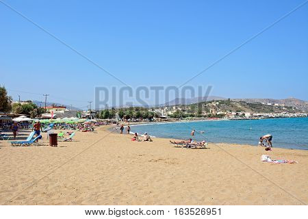 KALYVES, CRETE - SEPTEMBER 16, 2016 - Tourists relaxing on the beach with views towards the mountains Kalyves Crete Greece Europe, September 16, 2016.