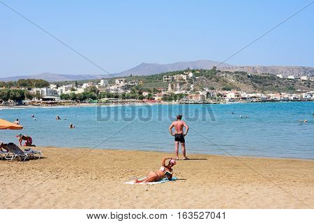 KALYVES, CRETE - SEPTEMBER 16, 2016 - Tourists relaxing on the beach with views towards the mountains Kalyves Crete Greece Europe, September 16, 2016.