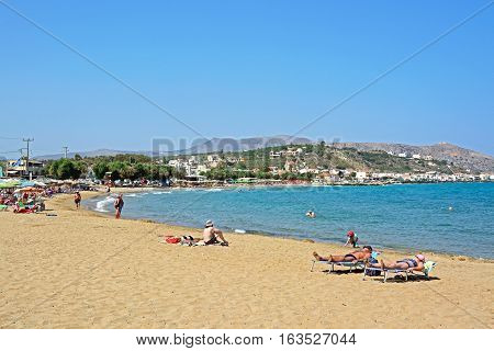 KALYVES, CRETE - SEPTEMBER 16, 2016 - Tourists relaxing on the beach with views towards the mountains Kalyves Crete Greece Europe, September 16, 2016.