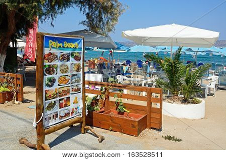 KALYVES, CRETE - SEPTEMBER 16, 2016 - Palm Beach restaurant menu board on the edge of the beach with views towards the Aegean sea Kalyves Crete Greece Europe, September 16, 2016.