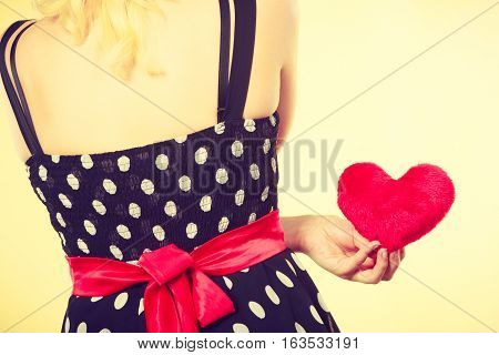 Valentine day gift proof of love romantic present concept. Woman in retro polka dot dress holding small furry red heart