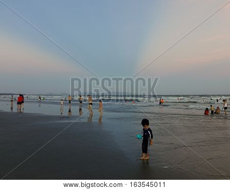 People Playing On The Beach At Sunset