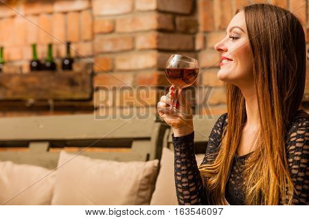 Woman Tasting Wine In Rural Cottage Interior