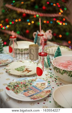 Christmas and New Year table place setting with empty Christmas plates with festive decorations bauble snowflake star bow ball pinecone berry candy cane. Christmas Xmas New Year holiday dinner background.
