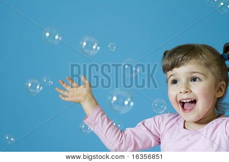 Little girl playing with bubbles
