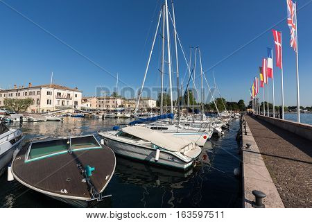 BARDOLINO ITALY - MAY 4 2016: Sailboats and fishing boats at Porto di Bardolino harbor on The Garda Lake . Italy