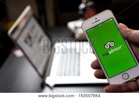 Bangkok, Thailand - December 14, 2016: Business man is using tripadvisor application to plan his trip.