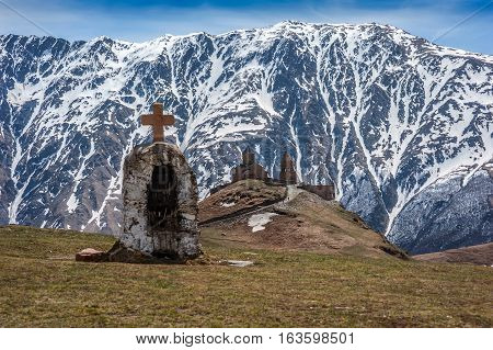 Georgia . Stepantsminda village . Gergeti Sameba Orthodox church on a background of mountain spring .