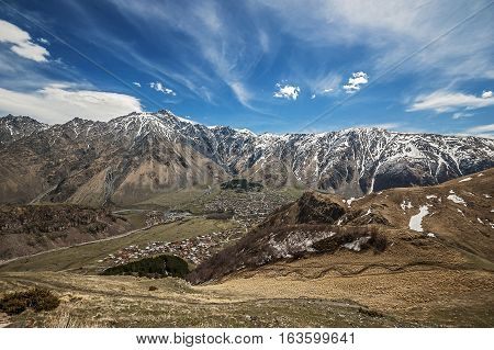 Georgia . Stepantsminda village . Gergeti Sameba Orthodox church on a background of mountain spring .