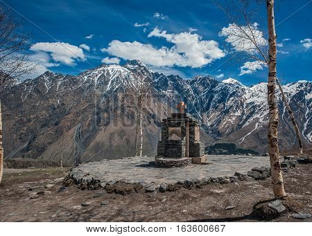 Georgia . Stepantsminda village . Gergeti Sameba Orthodox church on a background of mountain spring .