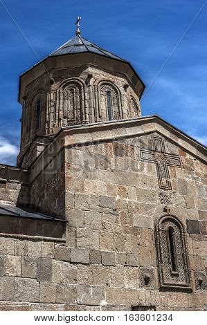 Georgia . Stepantsminda village . Gergeti Sameba Orthodox church on a background of mountain spring .