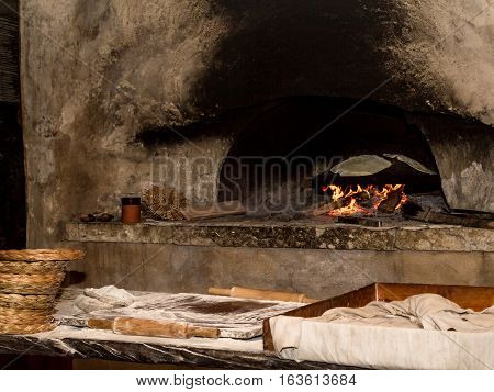 Baking flatbread on saj in outdoor oven in Nazareth Village Israel