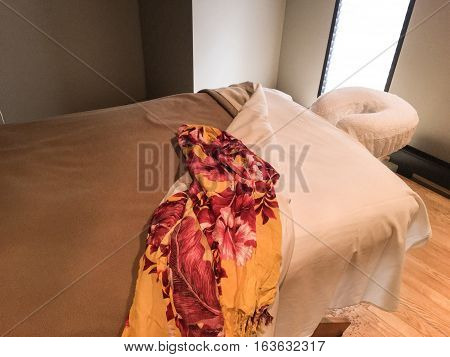 Relaxing Massage Table conceptual relax, no stress and self care healing background image with Hawaiian island wrap on table  isolated with room for copy