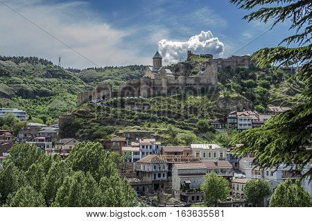 Georgia Tbilisi. View on Avlabari district houses on a cliff leaving the water in the Kura River .