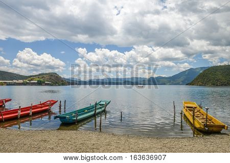 Colored boats anchored at wharf of Xiaoluoshui village, beautiful scenery of Lugu Lake, Lijiang, China