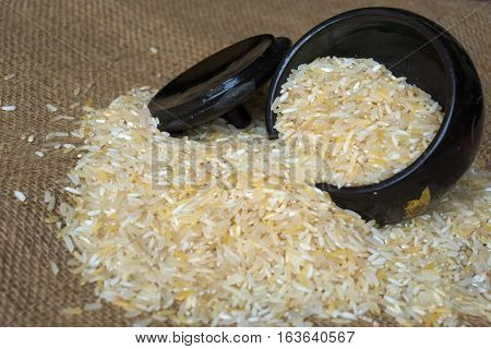 Rice in black wood container on the sack.