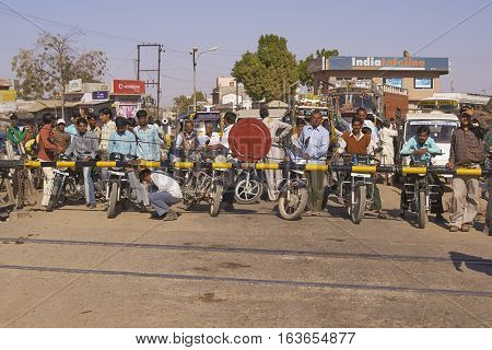 NAGAUR, RAJASTHAN, INDIA - FEBRUARY 16, 2008: Crowd of vehicles fill the road waiting for the barriers to rise at a level crossing in Nagaur, India.