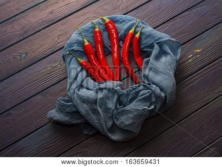 red chili pepper on the wood vintage blue table with the shawl