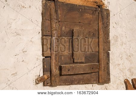 Old wooden window locked of an old house with signs of woodworm in a warehouse vintage