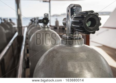 Row of aluminium scuba diving cylinders on dive deck of a luxury liveaboard motor yacht