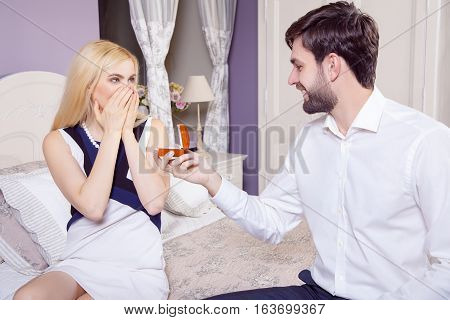 Handsome man doing a marriage proposal while offering his wife an engagement ring. Boyfriend make a marriage proposal to his girlfriend in valentine days.