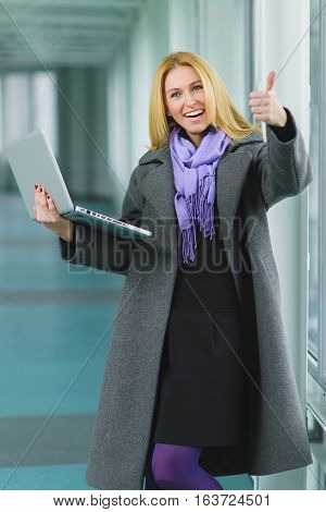 wondering and successful businesswoman showing thumbs up.