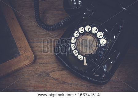 Black Antique Vintage Analog Telephone Dialling Or Scrolling Phone On Old Wall With Old Slate. Conta