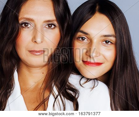 cute pretty teen daughter with mature mother hugging, fashion style brunette makeup close up, real happy family