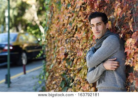 Handsome Man Wearing Winter Clothes In Wooden Background.