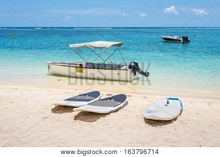 Le Morne Mauritius - December 7 2015: Windsurfing boards and boats on the Le Morne Beach one of the finest beaches in Mauritius and the site of many tourism facilities.