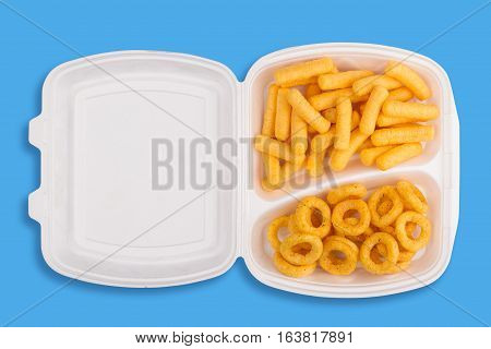 top view of junk food ingredients in a white take away packaging box on blue background calories concept